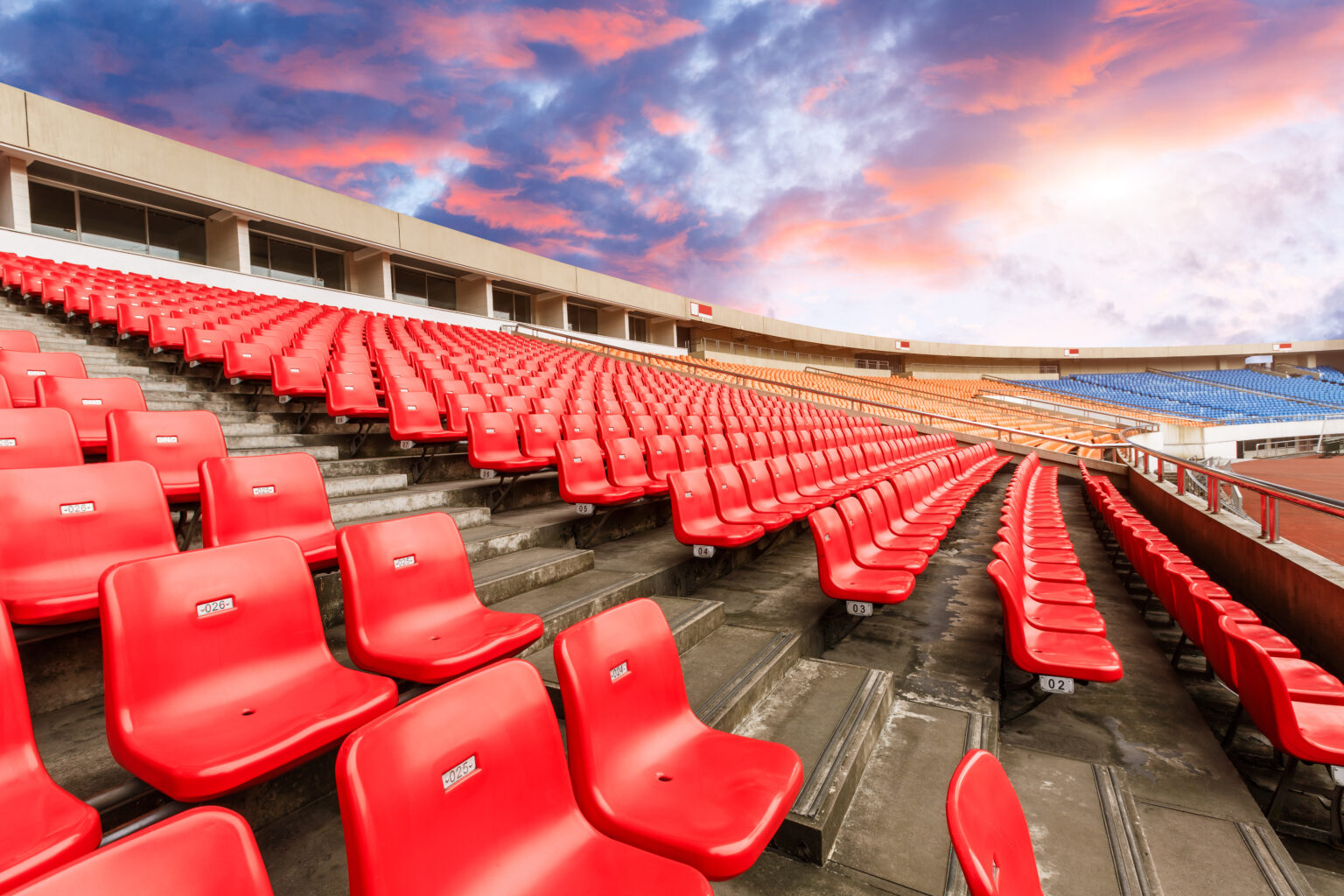 Rows of red seats inside an outdoor sports stadium